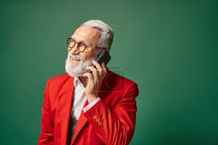 lustiger, stylischer Weihnachtsmann mit Brille und Bart, der telefoniert und wegschaut, Weihnachtskonzept