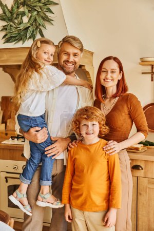 cheerful kids with smiling parents looking at camera in modern kitchen, cozy home environment