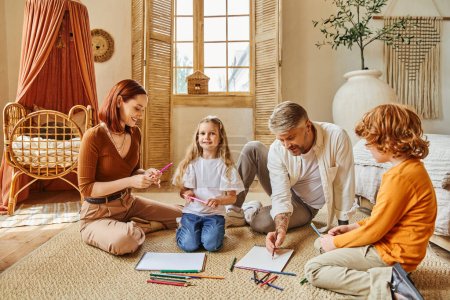 Lächelnde Eltern und Geschwister, die gemeinsam auf dem Boden im modernen Wohnzimmer zeichnen, kreative Aktivitäten
