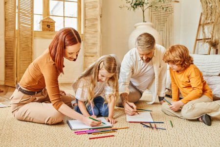 joyful parents and children drawing together on floor in modern living room, expressing creativity