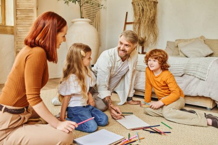 fröhliche Eltern und Kinder, die gemeinsam auf dem Fußboden im modernen Wohnzimmer zeichnen und Kreativität ausdrücken