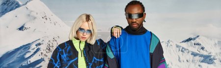 stylish couple in vibrant outfit with sunglasses posing on snowy backdrop, winter concept banner