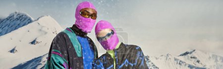 Téléchargez les photos : Élégant couple multiculturel dans des vêtements audacieux chauds et balaclavas roses, concept d'hiver, bannière - en image libre de droit