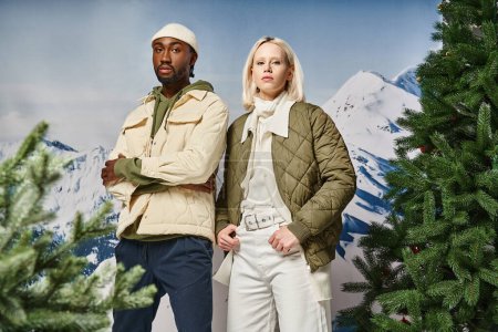 Photo for Stylish african american with crossed arms posing next to his voguish girlfriend, winter fashion - Royalty Free Image