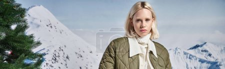 beautiful stylish woman in modish warm jacket with mountain backdrop, winter fashion, banner