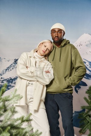 mujer bonita con brazos cruzados junto a su novio con las manos en los bolsillos, moda de invierno