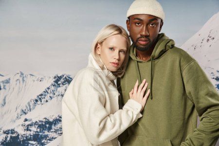 atractiva mujer posando con la mano en su pecho novio con telón de fondo de montaña, pareja de moda