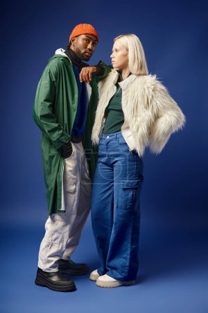 Téléchargez les photos : Couple multiethnique posant en tenue d'hiver avec montagne sur fond, homme et femme afro-américain - en image libre de droit