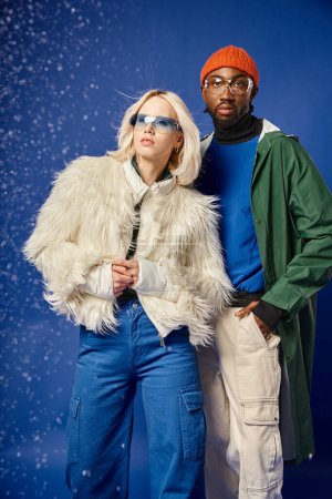 multiethnic couple posing in winter attire with mountain on backdrop, african american man and woman