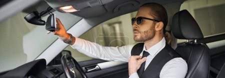 handsome professional in black vest with sunglasses behind steering wheel, business concept, banner