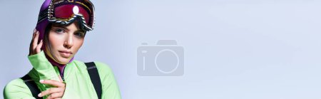 Téléchargez les photos : Portrait de femme en tenue active avec cagoule violette sur la tête regardant caméra sur gris, bannière - en image libre de droit