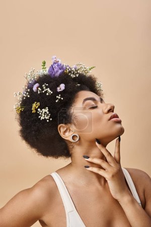 sensual african american woman with colorful flowers in hair posing with closed eyes on beige