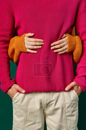 Teilansicht einer Frau, die ihren Freund in rosa Strickpulli umarmt, Hände eines liebenden Paares