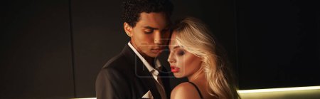 Téléchargez les photos : Jeune couple interracial amoureux en tenue de soirée posant amoureusement ensemble à la maison, bannière - en image libre de droit