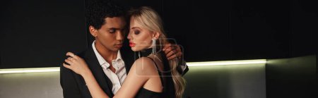 Téléchargez les photos : Attrayant couple interracial avec des accessoires dans des vêtements élégants posant ensemble dans la cuisine, bannière - en image libre de droit