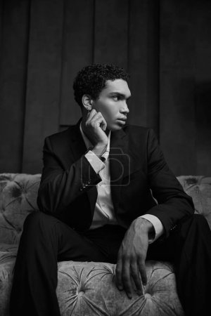 atractivo joven afroamericano modelo masculino en elegante traje de noche posando y mirando hacia otro lado