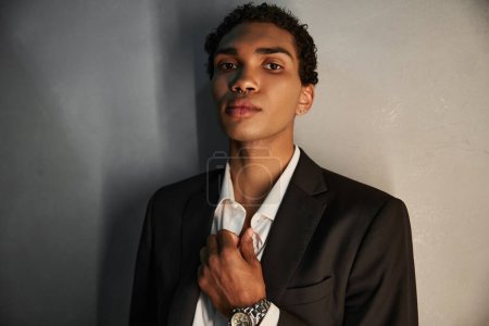 appealing handsome african american man in elegant suit with piercing in nose looking at camera