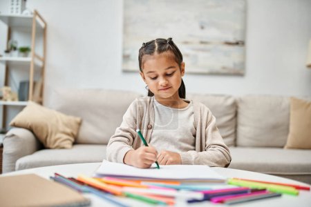 Porträt eines Mädchens im Grundalter, das mit Farbstift in einer modernen Wohnung zeichnet, Freizeit und Kunst