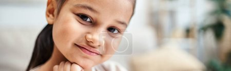 Téléchargez les photos : Portrait de fille d'âge élémentaire souriante avec des cheveux bruns regardant la caméra à la maison, bannière - en image libre de droit