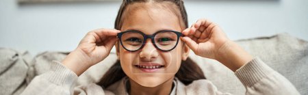 Téléchargez les photos : Heureuse fille d'âge élémentaire en tenue décontractée portant des lunettes et regardant la caméra, bannière - en image libre de droit