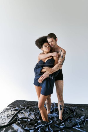 alluring young multiracial boyfriend and girlfriend in underwear hugging warmly, togetherness