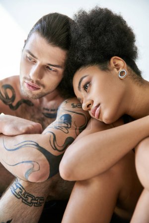 Téléchargez les photos : Beau jeune couple multiracial en sous-vêtements assis près de l'autre, ensemble - en image libre de droit