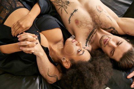 Téléchargez les photos : Vue du haut de multiculturel jeune copain et copine couché dans le lit ensemble, couple sexy - en image libre de droit