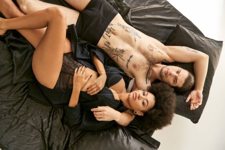 Téléchargez les photos : Vue du haut de divers beau petit ami et petite amie couché dans leur lit ensemble, couple sexy - en image libre de droit