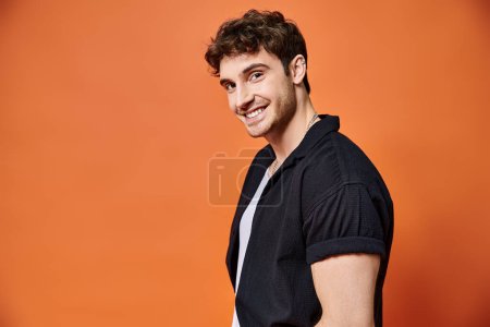 Photo for Cheerful young man in casual outfit on orange backdrop looking at camera, fashion concept - Royalty Free Image