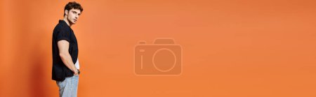 Photo for Good looking man in casual outfit on orange backdrop looking at camera, fashion concept, banner - Royalty Free Image