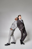 two handsome trendy multicultural male models in business smart attires posing on gray backdrop magic mug #685860668