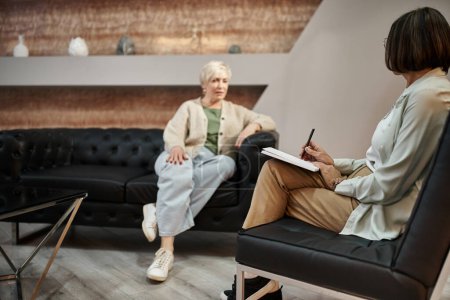 Fokus auf Psychologin mittleren Alters, die während der Therapiesitzung mit Klientin spricht