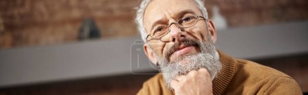 Porträt eines gutaussehenden Psychologen mittleren Alters mit Brille, der während der Arbeit in die Kamera schaut, Banner