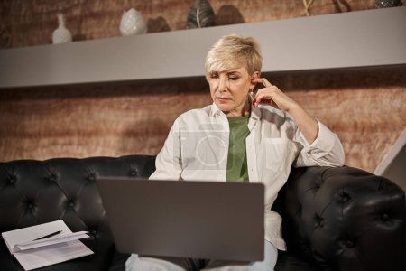 rubia psicólogo de mediana edad hablando con el cliente durante la consulta en el ordenador portátil, sesión en línea