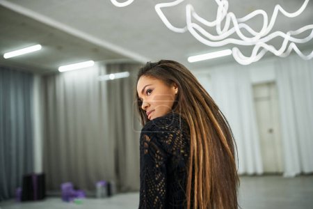 Photo for Stylish african american dancer in black knitted sweater looking away and rehearsing in studio - Royalty Free Image