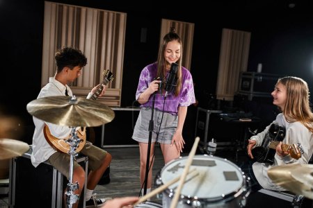 freudig begabte Teenager-Bandmitglieder in lässiger Kleidung, die verschiedene Instrumente singen und spielen