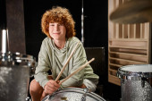cheerful adorable red haired teenager in casual vivid attire in front of drum set looking at camera magic mug #687122898