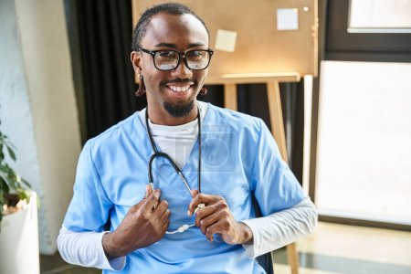 freudiger junger afrikanisch-amerikanischer Arzt mit Stethoskop und Brille, der lächelnd in die Kamera blickt