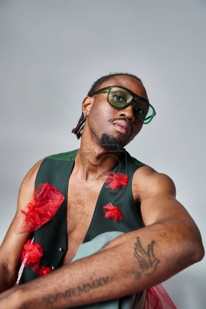 retrato de hombre afroamericano atractivo en ropa vibrante con gafas de sol, concepto de moda