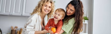 Téléchargez les photos : Heureux couple lesbien s'amuser avec leur mignon bébé fille tenant des mandarines, bannière - en image libre de droit