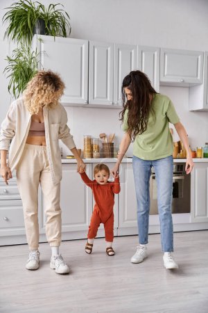 attractive jolly lesbian couple playing actively with their toddler daughter, modern parenting