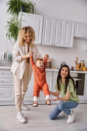 charming cheerful lesbian couple playing actively with their toddler daughter, modern parenting