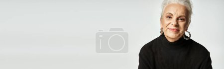 business portrait banner, happy middle aged business woman in turtleneck looking away on grey
