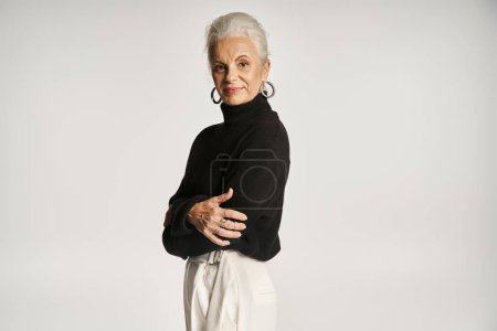 happy middle aged business woman in elegant smart casual attire posing on grey background