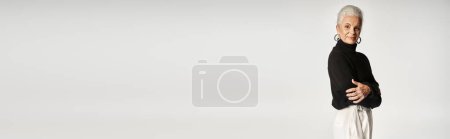 Téléchargez les photos : Heureuse femme d'affaires d'âge moyen dans une élégante tenue décontractée intelligente posant sur fond gris - en image libre de droit