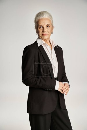 business portrait of attractive middle aged woman in white shirt and blazer looking at camera