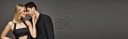 Photo for Banner of stylish couple posing on grey background, handsome man in suit and woman in black dress - Royalty Free Image