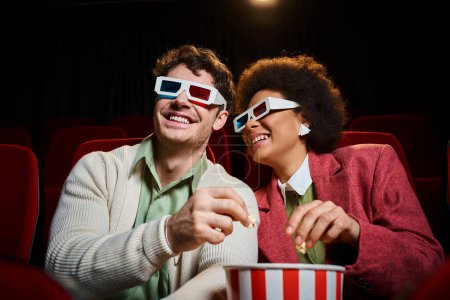 freudiges exotisches Paar mit Retro-3D-Brille, das am Valentinstag im Kino viel Spaß hat