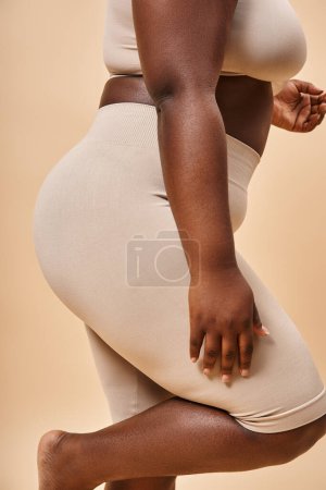 cropped view of plus size african american woman in underwear posing on beige backdrop, curvy body
