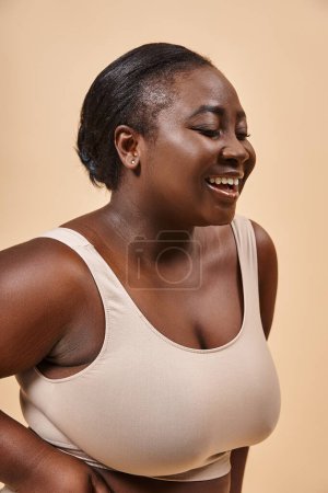 Photo for Happy african american plus size woman in beige underwear embracing self-love and confidence - Royalty Free Image